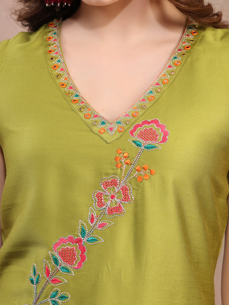 Close-up embroidery work on green kurta fabric